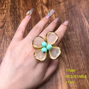 Close-up of a stylish adjustable flower ring with translucent petals and green bead center.