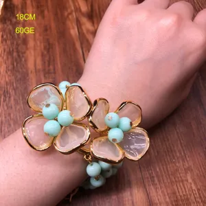 Detailed shot of the floral beaded bracelet worn on wrist, featuring translucent petals and gold rim.