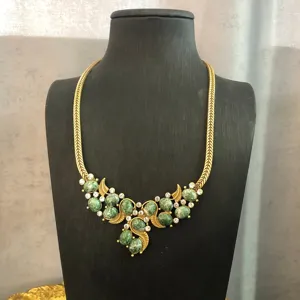 Vintage green stone embellished gold tone chain necklace detail shot, elegant collar accessory.