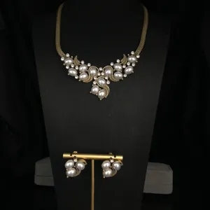 Vintage pearl rhinestone necklace and earrings set detail, antique gold tone jewelry display.