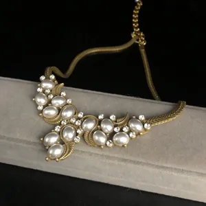 Vintage gold-tone faux pearl rhinestone statement necklace jewelry detail closeup