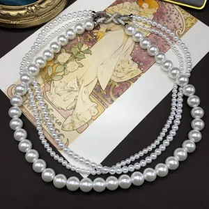 Detailed shot of multi-layer faux pearl beaded necklace with sparkling crystal clasp.