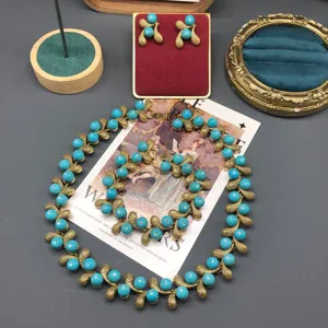 Vintage style turquoise peanut motif necklace and earrings jewelry set detail display showcase.