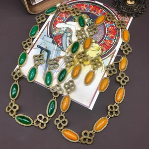 Vintage retro style long necklace and matching earrings set with green and orange stone details.