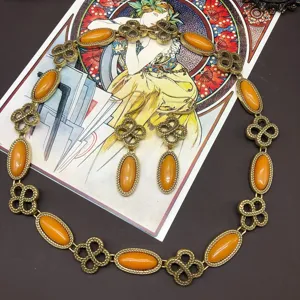 Detailed view of vintage bronze jewelry set featuring intricate knot links and amber stones.
