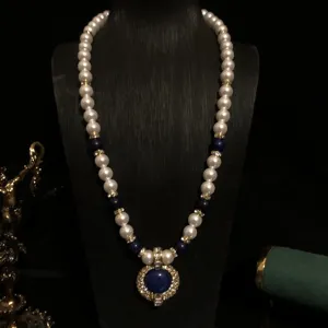 Vista detallada del collar de perlas falsas y lapislázuli de estilo corte vintage con colgante.