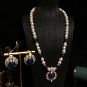 Vista detallada del elegante conjunto de collar y pendientes de perlas de estilo vintage.