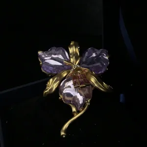 Broche orchidée en résine violette style vintage avec métal doré et détails de cristaux.