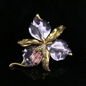 Détail de broche orchidée vintage en résine violette, métal doré et cristaux brillants pour femmes.