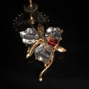 Broche orchidée style vintage avec pétales en résine transparente et tige dorée chic