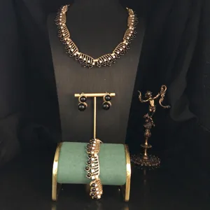 Vintage gold-tone filigree and black stone jewelry set detail, exquisite retro necklace and earrings.
