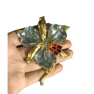 Broche fleur d'orchidée rétro vintage avec pétales en résine claire et cristaux rouges.