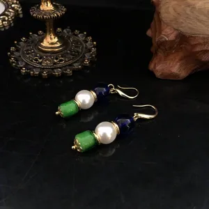 Nahaufnahme der eleganten dreifarbigen Perlen-Ohrhänger mit goldenen Haken.