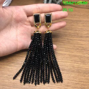 Detailed view of retro vintage long black beaded tassel earrings with gold rectangular stud.