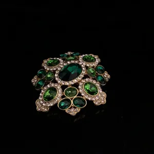 Detailed view of vintage emerald rhinestone brooch, exquisite floral crystal gold pin jewelry.