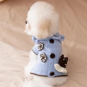 Close-up of cute knitted pet sweater detail, featuring bear applique and floral accents.
