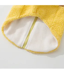 Primo piano dettaglio cerniera cappotto per animali in pile giallo e fodera calda.