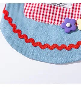 Dog dress detail shot featuring blue denim, red plaid pocket, and cute flower charms.