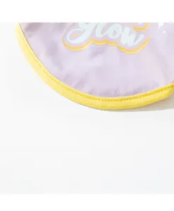 Pet clothing detail view, purple vest with yellow trim and graphic print for small dogs.