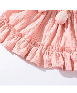 Detail van roze geplooide hondenjurk, zachte ademende stof met een lief tulp-accent.