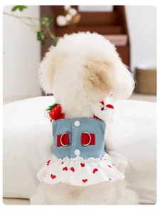 Close-up detail of cute dog denim strap dress with sweet strawberry and plush bear accents.