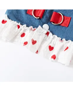 Detailed view of pet denim harness dress featuring red straps and cute heart print ruffles.