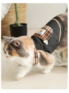 Close-up detail of cute cat denim strap dress featuring plaid pocket and sweet bear accent.