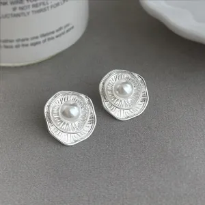 Elegante silberne Ohrstecker mit Perle und strukturierter Form für modebewusste Frauen.