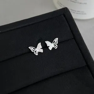 Nahaufnahme von filigranen Zirkonia Schmetterling Ohrsteckern, eleganter Silberschimmer glänzt.