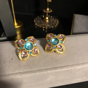 Vintage blue glass flower earrings detail, retro style gold-plated alloy stud jewelry.