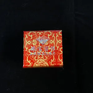 Boîte à bijoux rouge et dorée motif emballage pour bagues colliers rangement détail vue