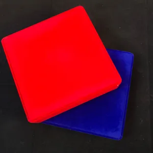 Vue détaillée de boîtes à bijoux carrées en velours empilées en rouge et bleu.