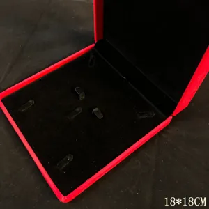 Gros plan sur l'intérieur de la boîte à bijoux en velours rouge avec fentes noires.