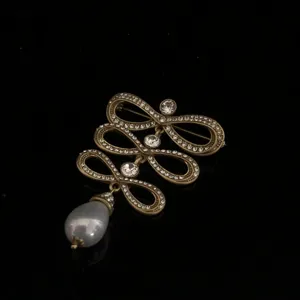 Exquisite vintage court style brooch featuring layered rhinestone loops and pearl pendant detail.
