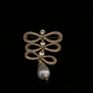 Vintage palace style rhinestone brooch with faux pearl pendant, antique gold tone detail.