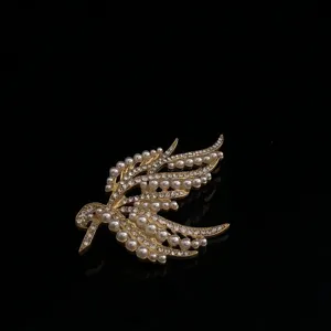 Vintage gold tone bird brooch featuring faux pearls and sparkling rhinestones for retro jewelry.