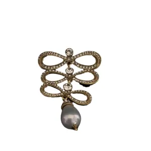 Vintage palace style heavy duty brooch with rhinestones and grey pearl pendant accessory.
