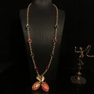 Lange gouden statement ketting met kleurrijke stenen en schitterende ananas hanger.