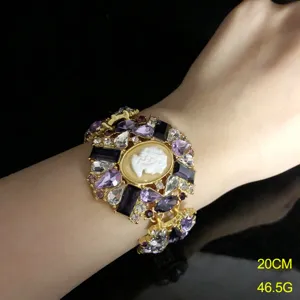 Vintage cameo crystal bracelet detail shot, elegant purple rhinestone gold cuff jewelry piece.