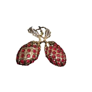 Elegante goudkleurige dubbele ananas broche met fonkelende rode kristallen en strass bladeren.