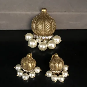 Close-up detail view of vintage gold-toned dome pendant and matching pearl earrings set.
