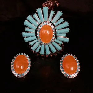 Detailed close-up view of the vintage turquoise and orange crystal brooch earrings set.