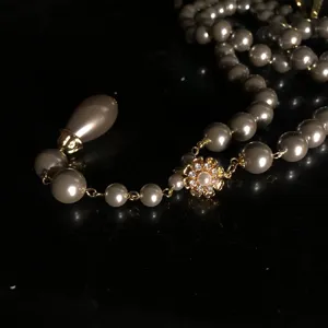 Vintage Stil graue Glasperle lange Kette mit goldenem Blumenverschluss und Anhänger.