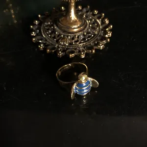 Gold plated bee ring featuring blue enamel stripes and green crystal eyes. Fashion nature jewelry.