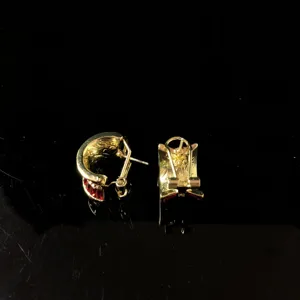 Close-up detail of vintage style gold-plated red stone earrings, showing back structure.