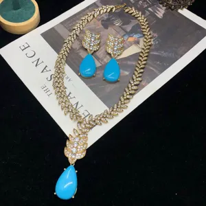 Vista detallada del conjunto de collar con hojas de estrás doradas vintage y pendientes.