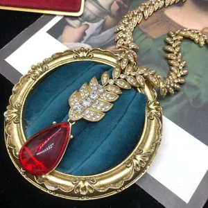 Collar hoja estrás oro estilo barroco vintage con elegante detalle colgante gota rojo.