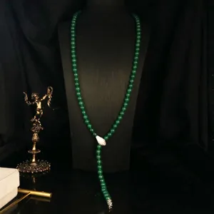 Vintage green bead Y-necklace with snake motif, elegant dark style jewelry detail view.