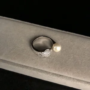 Detailed view of retro snake head ring with sparkling zirconia and smooth pearl accent.