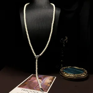 Detailed view of the elegant pearl lariat necklace featuring a sparkling zirconia snake head.